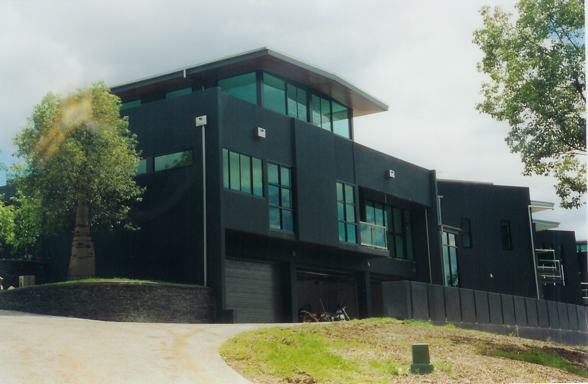 Front elevation of the Mt Nebo home showcasing dark cladding, glazed upper level, and a strong geometric form responding to the slope.